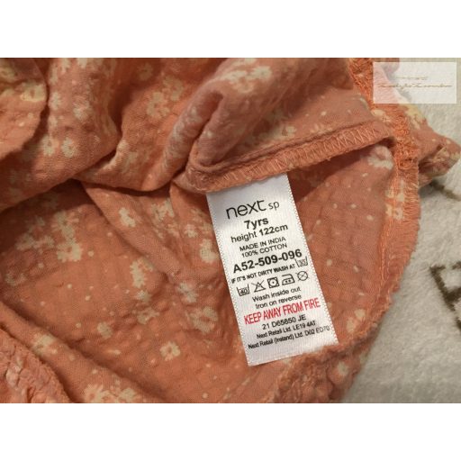 Next 7 év 122 cm  barackvirág színű, fehér virágmintás vékony krepp lány rövid playsuit újszerű,hibátlan